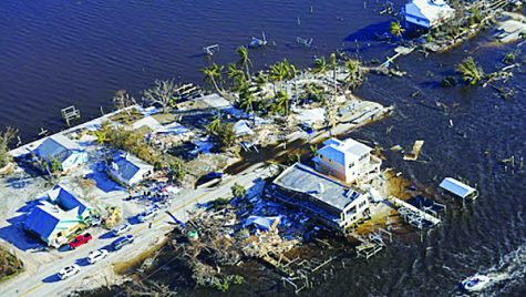 U.S. Army National Guard Blackhawk helicopter captures wreckage of homes and businesses in Pine Island, Florida.