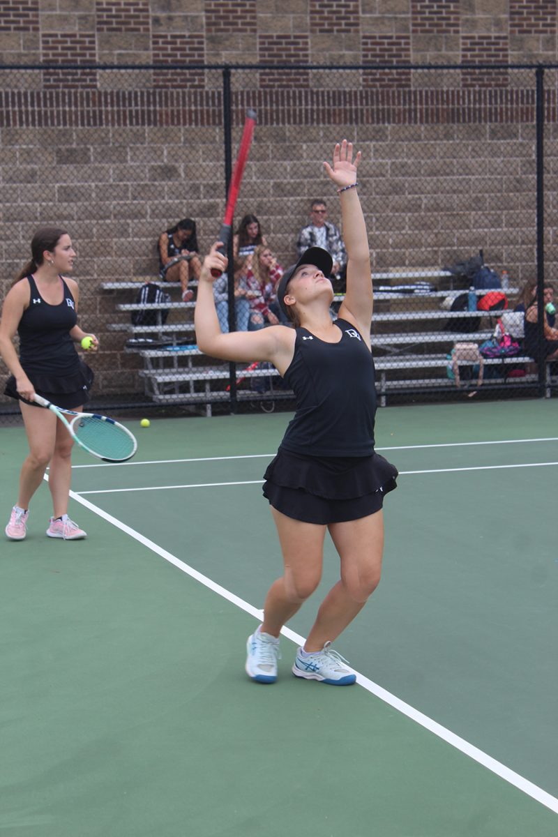 Senior Noelle Holderith practices her serve before her match