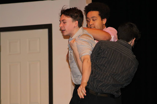 The Foreman and Juror 10 attempt to restrain an angry Juror 3 as he struggles to convince the jury of the defendant’s guilt.